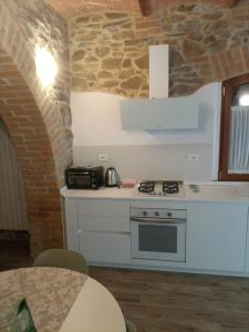 cocina con fogones y pared de piedra en Podere Feltrino, en Grosseto