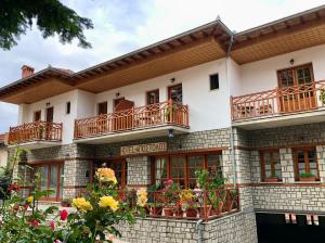 un edificio con balconi e fiori di fronte di Apostolos Hotel a Metsovo