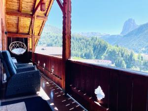 een balkon van een hut met uitzicht op de bergen bij Chalet Bernardi Apartments in Ortisei