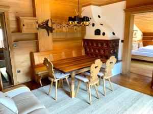 een eetkamer met een houten tafel en stoelen bij Chalet Bernardi Apartments in Ortisei