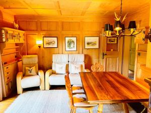 een eetkamer met een houten tafel en stoelen bij Chalet Bernardi Apartments in Ortisei