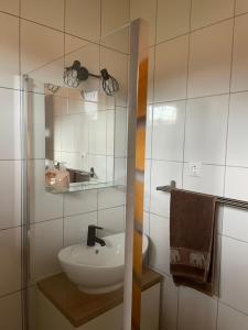 a bathroom with a sink and a mirror at Győri vendégház in Demjén