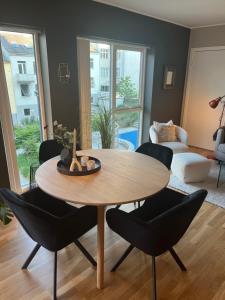 sala de estar con mesa de madera y sillas en Modern Apartment - Amazing Terrace and Fjord View, Close to City Center, en Bergen