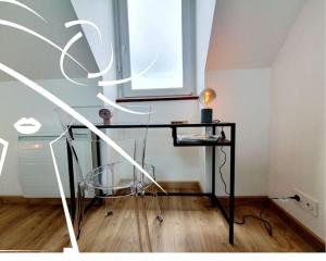 a room with a table and a glass chair at Pop & Suite par Madame Conciergerie in Rennes