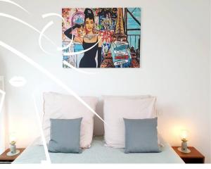 a bed with two pillows and a painting above it at Pop & Suite par Madame Conciergerie in Rennes