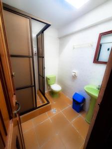 uma casa de banho com um WC verde e um lavatório em Cabañas Utama em Copacabana