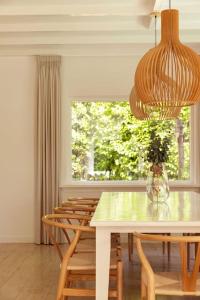 d'une salle à manger avec une table, des chaises et une fenêtre. dans l'établissement Stylish villa 12p with private pool in the Veluwe, à Garderen