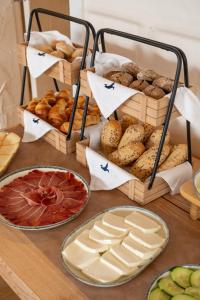 - une table avec différents types de pain et de viennoiseries dans l'établissement Praia FLH Hotels Ericeira, à Ericeira