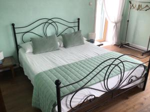 a bedroom with a bed with a green and white comforter at Villa Mazza al Vesuvio in Torre del Greco