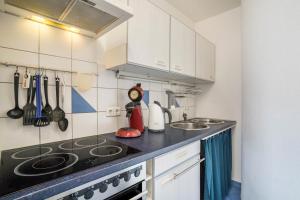 a kitchen with white cabinets and a stove top oven at Ferienwohnung Schläfer in Kappel-Grafenhausen