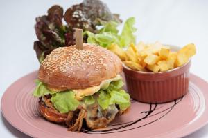 um prato com uma sanduíche e batatas fritas e uma salada em Le Domaine (Swiss Lodge) em Fribourg