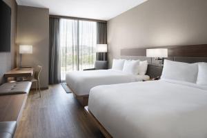 A bed or beds in a room at AC Hotel by Marriott Lansing University Area