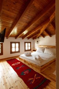 Schlafzimmer mit einem großen Bett und Holzdecken in der Unterkunft Hotel Sarajet 1821 in Gjirokastër