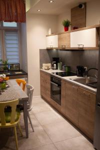 une cuisine avec des placards en bois et une table avec une salle à manger dans l'établissement Lukas Guest Rooms, à Cracovie