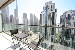 迪拜Luxury Apartment burj khalifa & city view的一个带桌子和两把椅子的阳台和一个城市