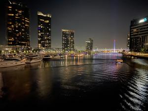 um horizonte da cidade à noite com barcos na água em Yarra Accommodation with new Private Apartment em Melbourne