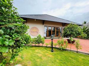 GOLDEN LOTUS SPA & HOMESTAY في Ấp Thiện Phước: منزل أمامه حديقة