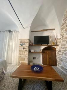 a living room with a table and a tv at Cozy stone built apartment in Nénita! in Chios