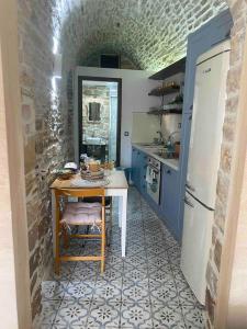 a kitchen with a table and a refrigerator at Cozy stone built apartment in Nénita! in Chios