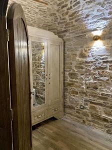 a bathroom with a mirror and a stone wall at Cozy stone built apartment in Nénita! in Chios