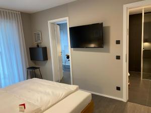 sypialnia z łóżkiem i telewizorem z płaskim ekranem na ścianie w obiekcie Timehouse Serviced Apartments w Monachium