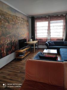 una sala de estar con sofá y una pintura en la pared en Apartment Maximilian, en Bratislava