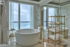 La salle de bains est pourvue d'une baignoire et d'une grande fenêtre. dans l'établissement The St. Regis Zhuhai, à Zhuhai