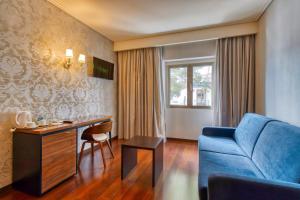 a living room with a blue couch and a table at Hotel Lis Batalha in Batalha