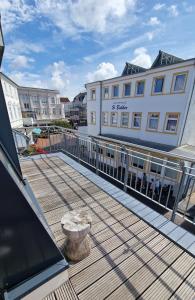 una terrazza in legno con un edificio e un edificio di Seebox Appartment 6 a Norderney