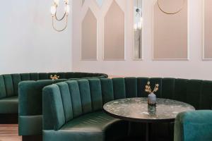 a waiting room with green chairs and a table at Hotel Berlin, Berlin, a member of Radisson Individuals in Berlin