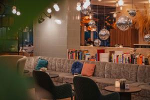 a couch in a room with chairs and books at Hotel Berlin, Berlin, a member of Radisson Individuals in Berlin