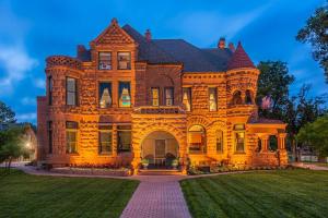 une grande maison en briques avec une pelouse devant elle dans l'établissement Orman Mansion - Pueblo's Most Luxurious Stay!, à Pueblo