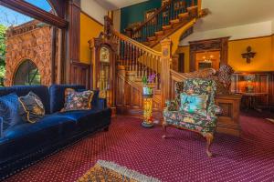 - un salon avec un canapé bleu et un escalier dans l'établissement Orman Mansion - Pueblo's Most Luxurious Stay!, à Pueblo