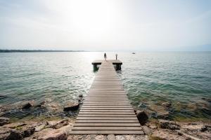 ペスキエーラ・デル・ガルダにあるGlamping Lake Gardaの水上桟橋に立つ者