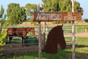 un segno con l'ombra di un cavallo dietro una recinzione di Agriturismo Gli Etruschi a Populonia