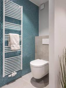 bagno con servizi igienici e parete blu di Renovated 2 Bedroom Apartment with Parking & AC a Lussemburgo