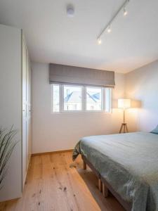 una camera bianca con un letto e una finestra di Renovated 2 Bedroom Apartment with Parking & AC a Lussemburgo