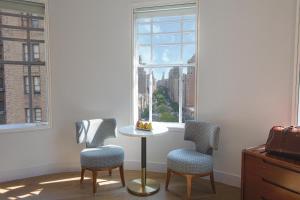 een kamer met 2 stoelen, een tafel en een raam bij Hotel Belleclaire Central Park in New York