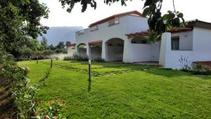 uma casa com um relvado verde em frente em Sa Jacca Albergo Rurale em Siniscola