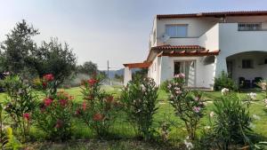 uma casa com flores em frente a um quintal em Sa Jacca Albergo Rurale em Siniscola