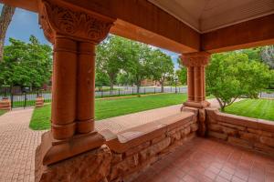 une terrasse couverte avec un mur en pierre et des arbres dans l'établissement Orman Mansion - Pueblo's Most Luxurious Stay!, à Pueblo