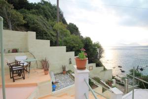 un balcone con tavolo, sedie e acqua di Maeiz Skopelos a Skopelos Town