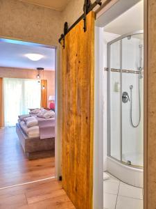 ein Schlafzimmer mit einem Bett und ein Badezimmer mit einer Dusche in der Unterkunft Parkhotel Bad Griesbach in Bad Griesbach