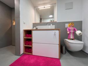 La salle de bains est pourvue de toilettes et d'un tapis rose. dans l'établissement CR25 - more than a room, à Immenstadt