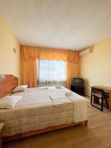 a bedroom with a large bed and a window at Guest House Italia in Kavarna