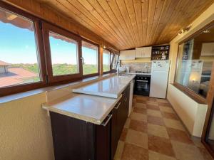 a kitchen with a counter top and some windows at Guest House Italia in Kavarna