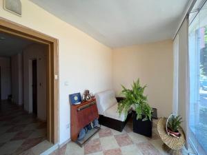 a living room with a white chair and a table at Guest House Italia in Kavarna