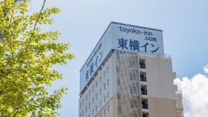 富山Toyoko Inn Toyama eki Shinkansen guchi No 1的上面有标志的建筑