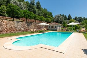 uma piscina em frente a uma parede de pedra em Quinta do Calvário 