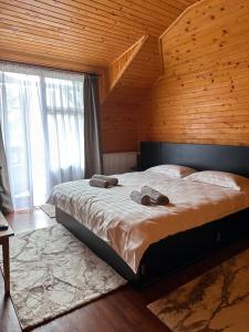 Cette chambre en bois comprend un grand lit. dans l'établissement Ollie's Mountain Chalet, à Buşteni